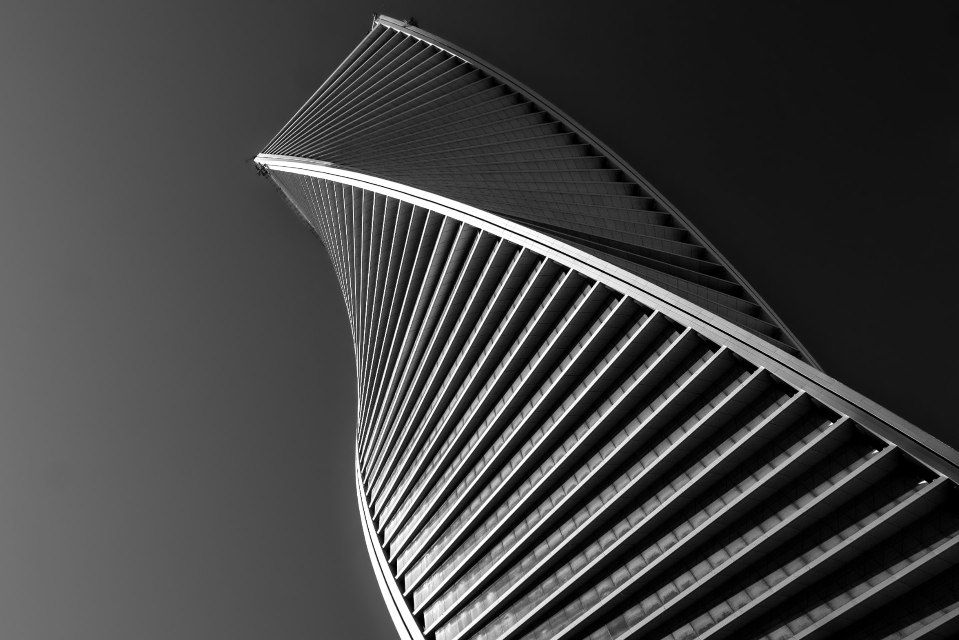 Sculptural modern tower with sweeping diagonal ribs against an open sky