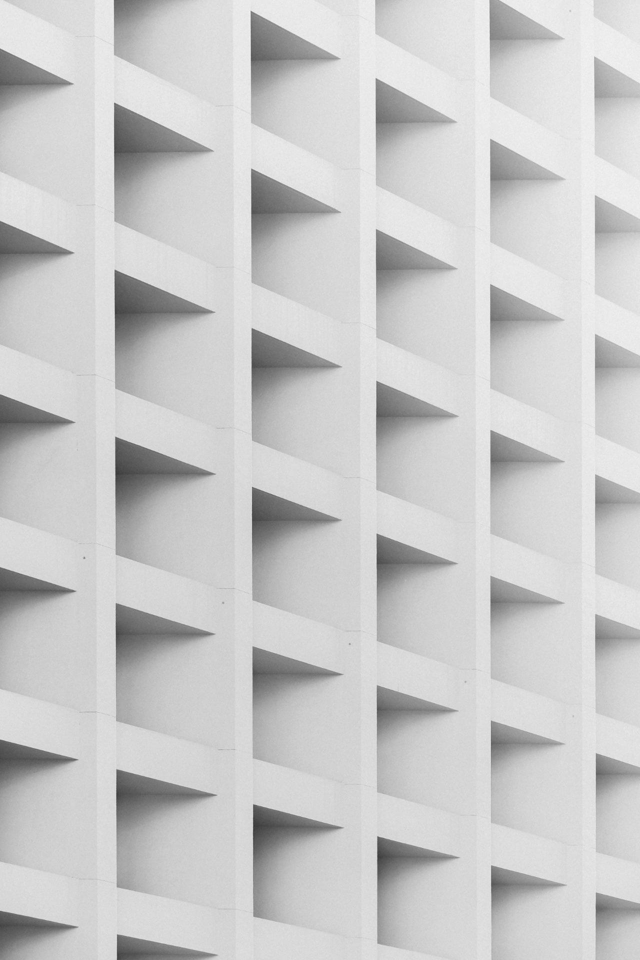 White geometric facade with repeating triangular recesses