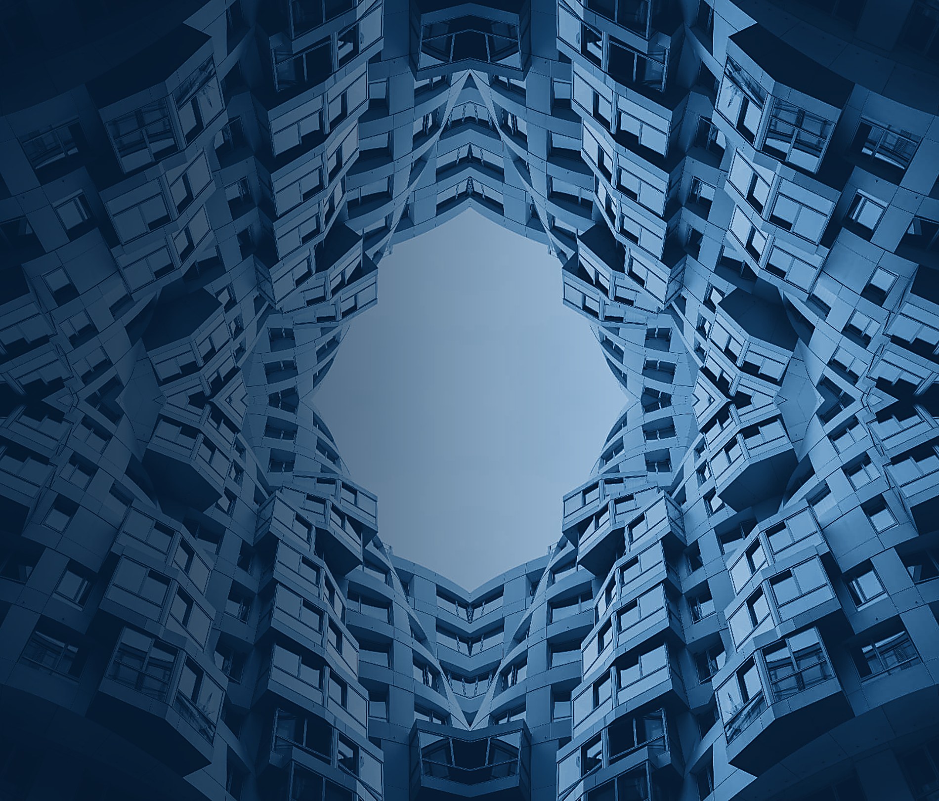 Symmetrical monochrome facade mirrored around a central opening to the sky